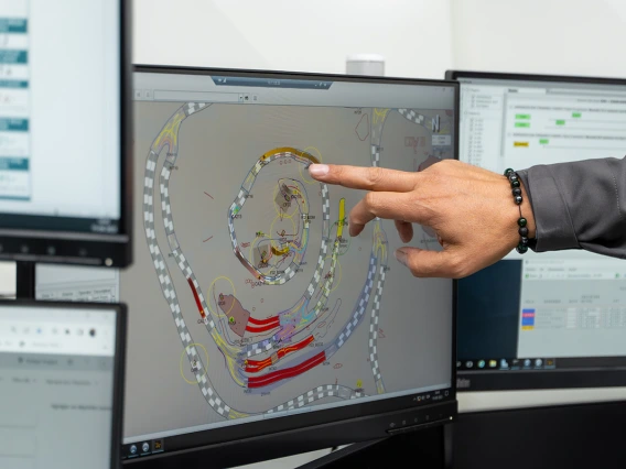 A person points at a computer screen.