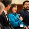 Three fellow panelists listen to Dawn Wellman, speaking with a microphone.
